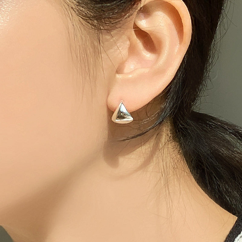 Polished sterling silver huggie hoop earrings with a sculpted triangular dome form, offering a clean, minimalist aesthetic ideal for everyday wear or understated styling.