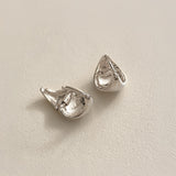 Solid sterling silver dome huggie hoops crafted in a softly angular triangle shape, designed to hug the ear with comfort while adding a contemporary sculptural detail.