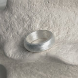 Thick sterling silver band ring in a sculptural rounded form with a muted matte finish, evoking an old money aesthetic and subtle sophistication.