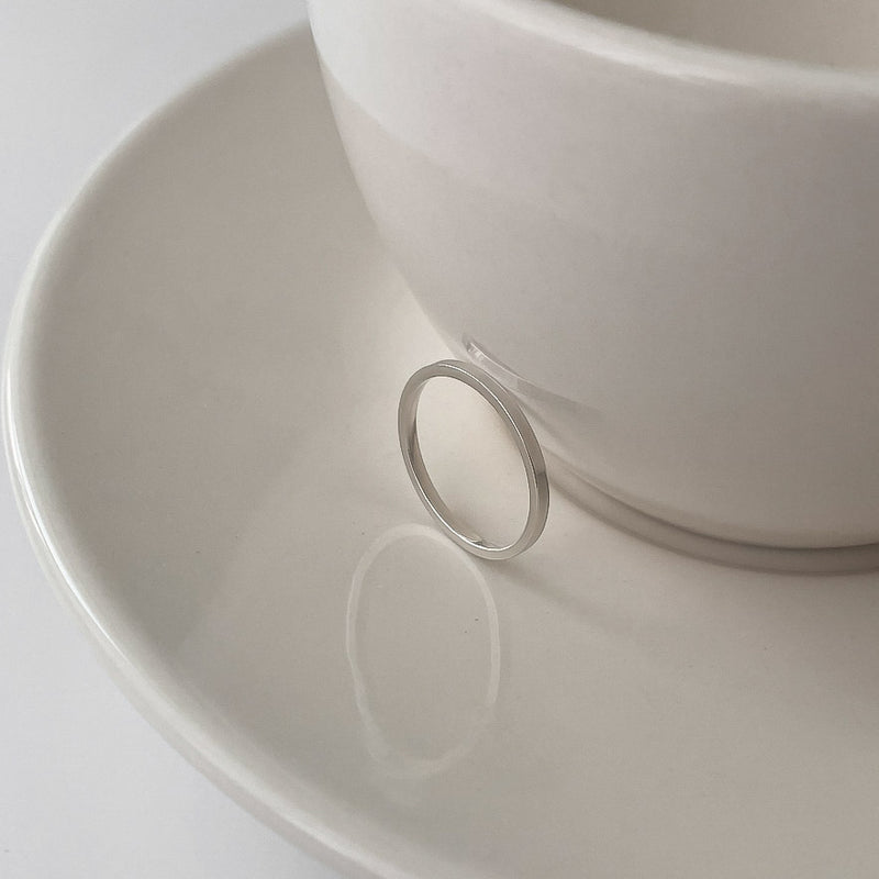 Classic band ring in sterling silver with a smooth, flat edge and slender width. Great for modern minimalists.

