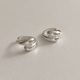 Chunky silver mini hoops with a double dome teardrop shape. These sterling silver huggie earrings feature smooth, voluminous curves that hug the earlobe, offering a modern and sophisticated look for any occasion.