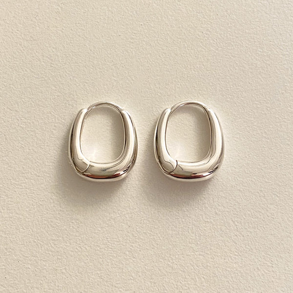 A pair of sterling silver rounded square huggie hoops with a clean, sculptural form, ideal for lovers of minimal design and refined craftsmanship.