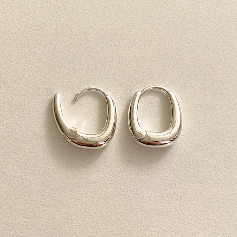 Minimalist silver earrings with a chunky rounded square shape, exuding contemporary sophistication and sculptural fluidity in every angle.