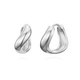 Polished sterling silver earrings in a smooth, wave-like form that hugs the earlobe with refined sculptural volume and a minimalist yet striking presence.
