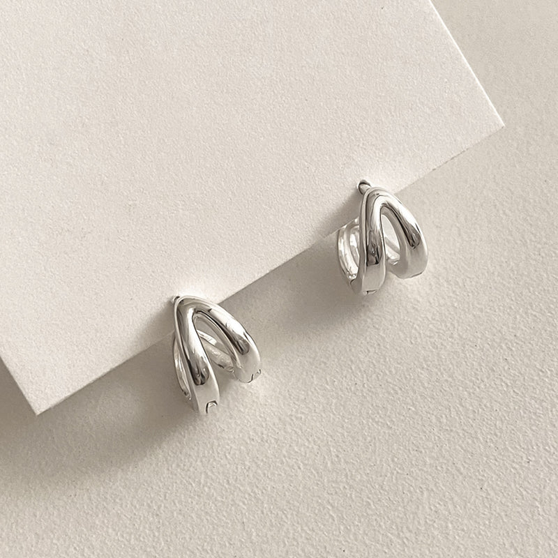 Minimalist silver mini hoops with a twin-line design that offers texture and visual interest, ideal for those seeking subtle statement earrings with a clean, modern look.

