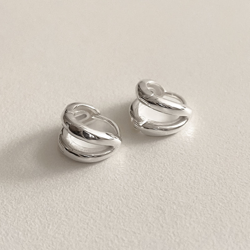 Sculptural sterling silver huggie earrings featuring two parallel lines in a sleek, compact form, designed to add a hint of edge and elegance to casual and formal outfits alike.

