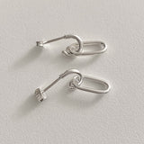 Sculptural oval drop earrings in sterling silver, crafted with clean interlocking chain links that combine structure and flow, offering a sleek, architectural look for day-to-night wear.


