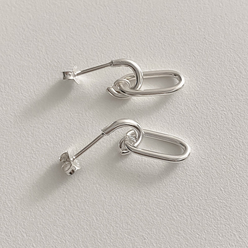 Sculptural oval drop earrings in sterling silver, crafted with clean interlocking chain links that combine structure and flow, offering a sleek, architectural look for day-to-night wear.

