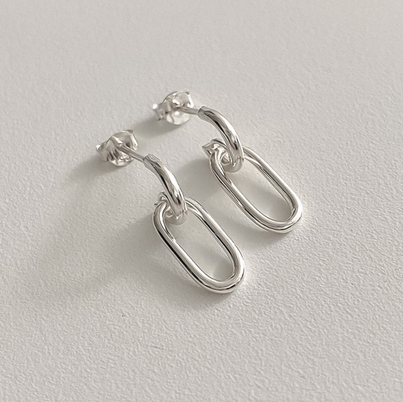 Oval link drop earrings made of sterling silver with a lightweight structure and sculptural design, ideal for adding a subtle yet sophisticated accent to everyday or formal wear.

