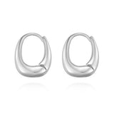 Sculptural sterling silver huggie hoop earrings in a rounded square silhouette, featuring a bold yet smooth contour for a modern, high-fashion aesthetic.
