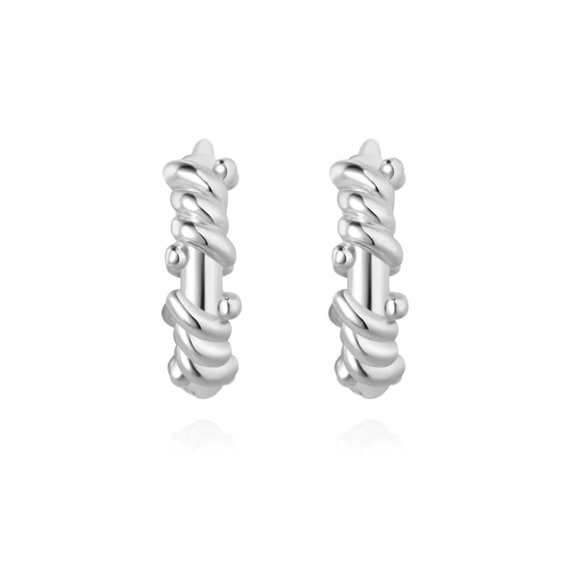 Sterling silver twisted rope huggie hoops with sculptural texture, classic design, and timeless elegance for versatile everyday wear.
