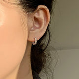 Elegant sculpted rope huggie earrings with bold sterling silver curves, polished finish, and a timeless, classic silhouette.