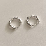 Handcrafted sterling silver rope hoop earrings with sculptural twist texture, modern minimalist style, and everyday versatility.