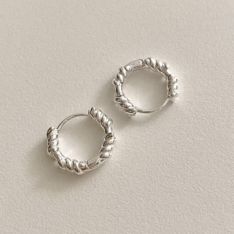 Twisted rope huggie hoop earrings with a sleek sterling silver finish, ideal for classic, old money style and minimal fashion.