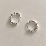 Sterling silver sculpted rope hoops with bold yet refined twisted curves, perfect for gifting or adding a chic everyday statement.