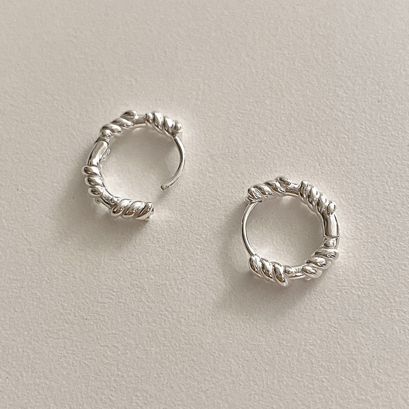 Sterling silver sculpted rope hoops with bold yet refined twisted curves, perfect for gifting or adding a chic everyday statement.