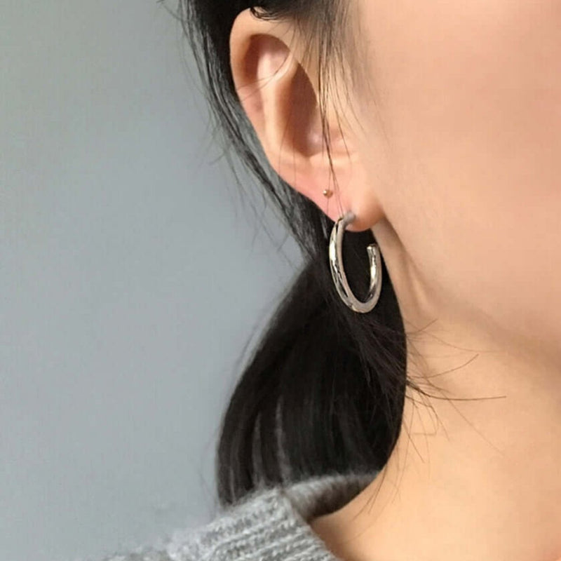 Classic silver hoop earrings for women, featuring a sleek and polished design with a smooth, rounded finish.